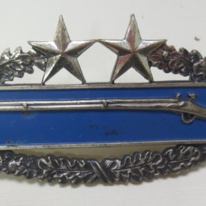 Badge with the symbol of shotgun at the center and stars on top