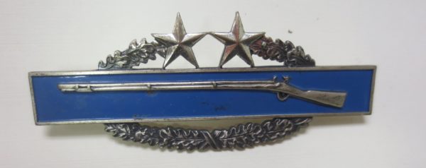 Badge with the symbol of shotgun at the center and stars on top