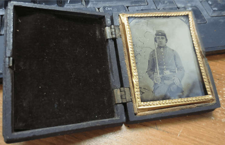 Opened case containing a frame of soldier's photo holding sword